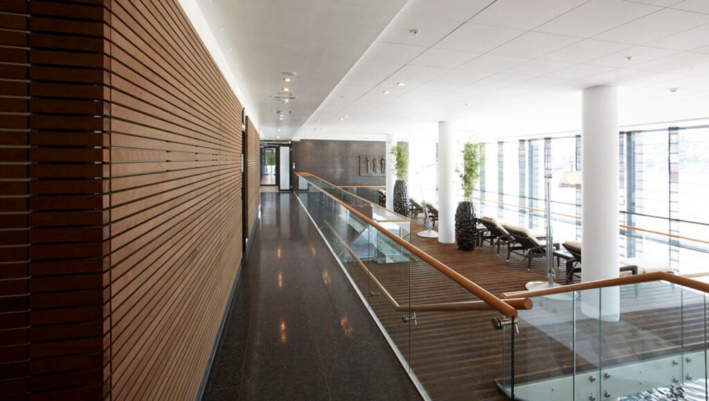 Decorative-Wall-Panels-Accented-by-Wood-Elements-Combined-with-Transparent-Railing-at-Second-Floor-of-House-and-Tiny-Ceiling-Lights-on-Solid-Wall